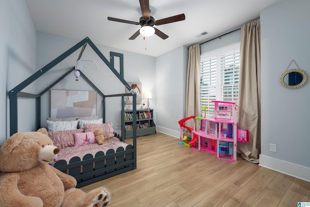 bedroom with light wood finished floors, visible vents, and baseboards