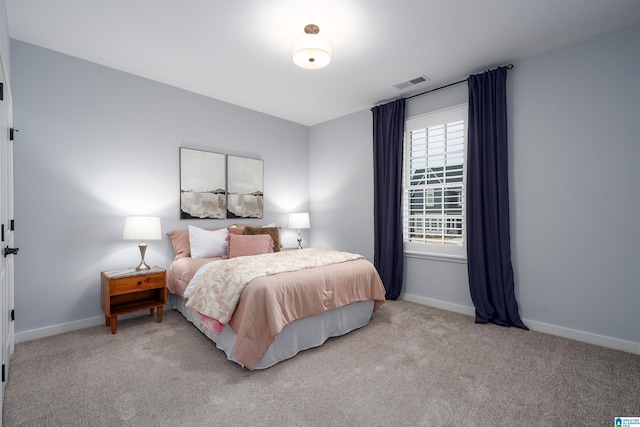 bedroom featuring visible vents, light carpet, and baseboards