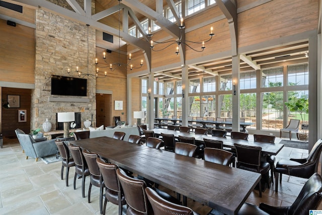 dining room featuring a healthy amount of sunlight, a notable chandelier, wooden walls, and a high ceiling