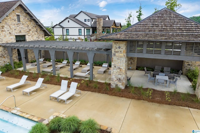 view of patio with a community pool and a pergola