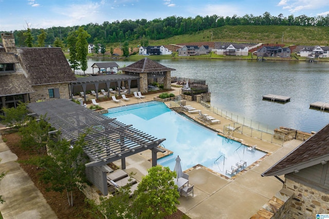 community pool with a water view and a pergola