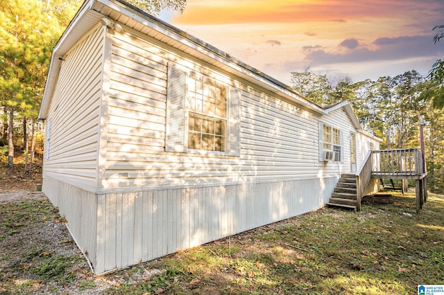 property exterior at dusk with cooling unit and a wooden deck