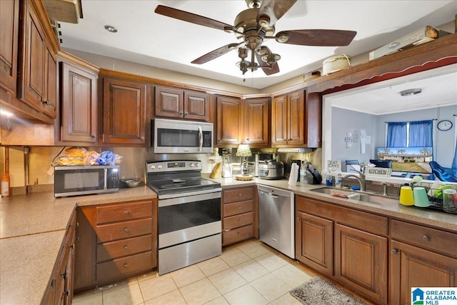 kitchen featuring ceiling fan, appliances with stainless steel finishes, sink, and light tile patterned floors