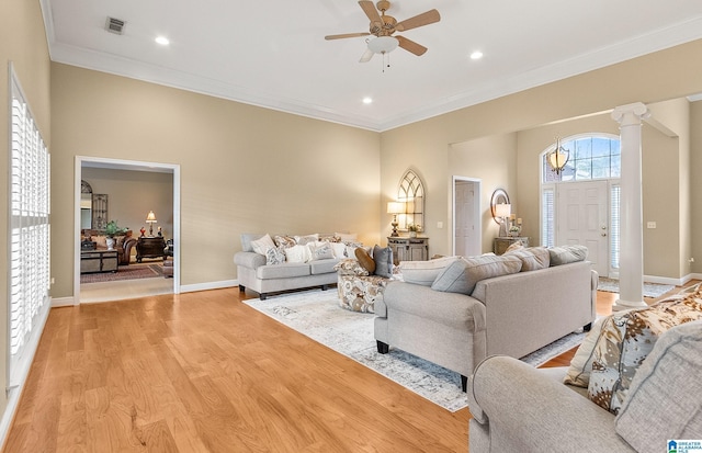 living room with decorative columns, ornamental molding, ceiling fan, and light hardwood / wood-style flooring