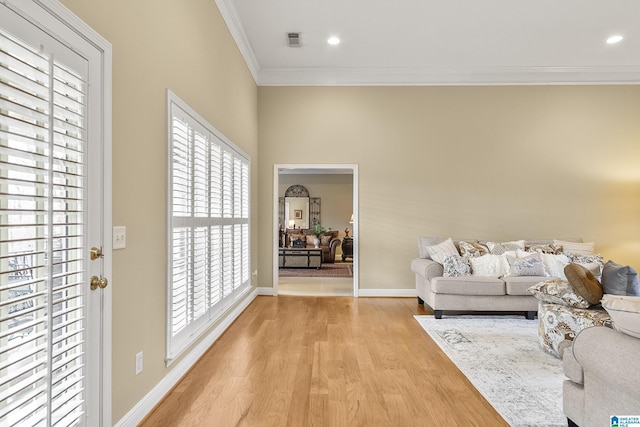 living room with light hardwood / wood-style flooring and ornamental molding