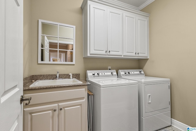 laundry area featuring cabinets, washing machine and dryer, sink, and crown molding