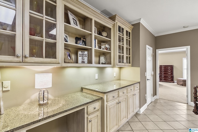 kitchen with ornamental molding, light stone countertops, and light tile patterned floors