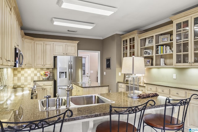 kitchen with appliances with stainless steel finishes, sink, dark stone countertops, backsplash, and kitchen peninsula