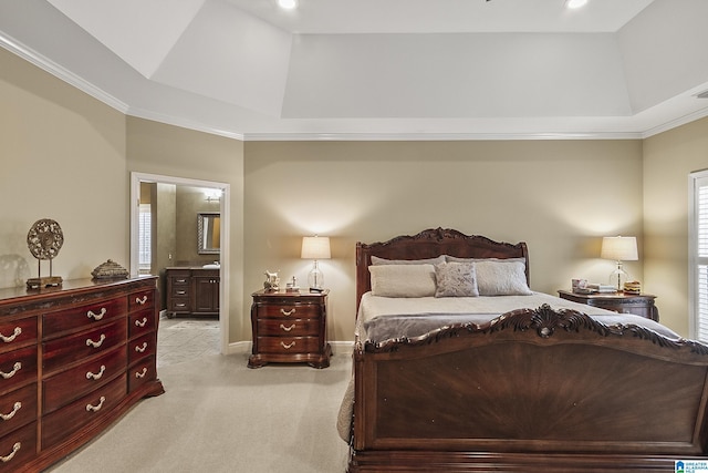 carpeted bedroom featuring ornamental molding, ensuite bath, and a tray ceiling