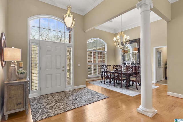 entryway featuring hardwood / wood-style flooring, a towering ceiling, and ornate columns