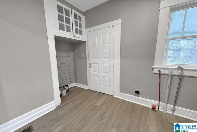 clothes washing area with wood-type flooring