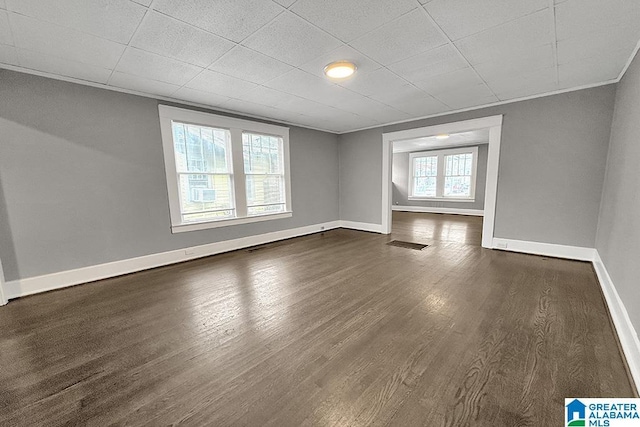 spare room featuring ornamental molding and dark hardwood / wood-style floors