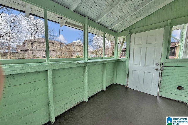 unfurnished sunroom with wood ceiling, a healthy amount of sunlight, and lofted ceiling with beams