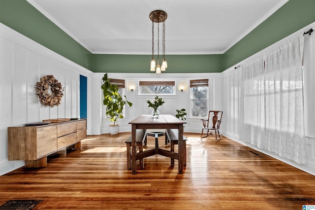 dining space featuring hardwood / wood-style flooring and ornamental molding