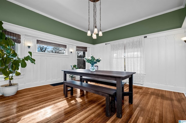 dining space with hardwood / wood-style flooring and ornamental molding