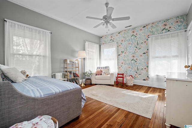 bedroom with ornamental molding, hardwood / wood-style flooring, and ceiling fan