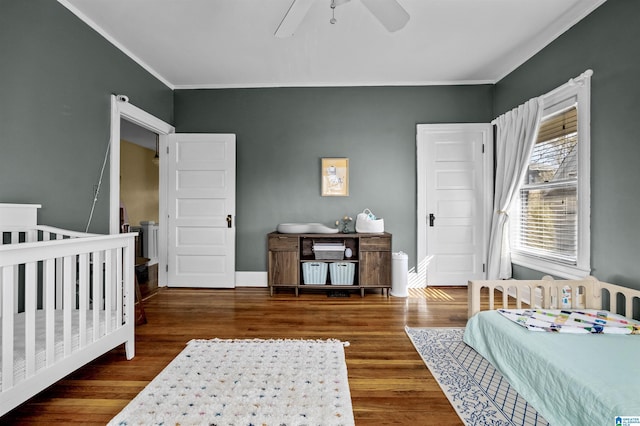 bedroom with ceiling fan, dark hardwood / wood-style floors, and ornamental molding