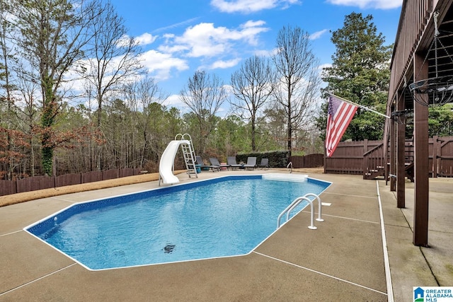 view of pool with a water slide and a patio area