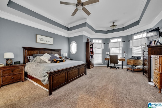 carpeted bedroom with a raised ceiling, ornamental molding, and ceiling fan