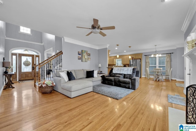 living room featuring crown molding, light hardwood / wood-style flooring, and ceiling fan with notable chandelier