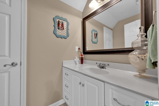 bathroom with vanity and lofted ceiling