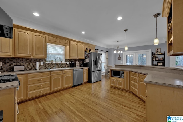 kitchen featuring decorative light fixtures, ornamental molding, stainless steel appliances, and light brown cabinets