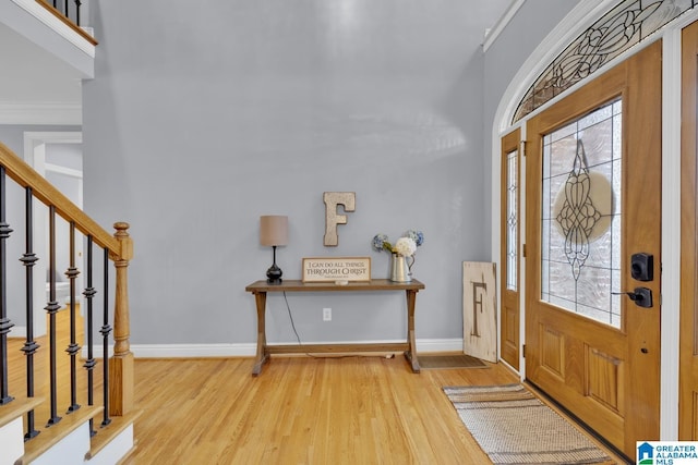 entryway with hardwood / wood-style flooring and crown molding