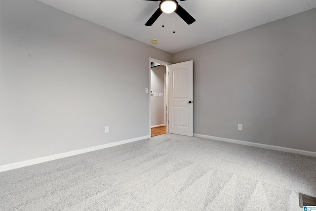 carpeted spare room featuring ceiling fan