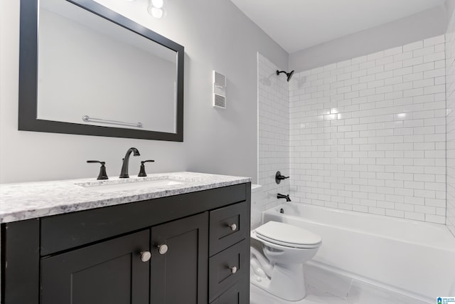 full bathroom featuring vanity, tiled shower / bath, and toilet