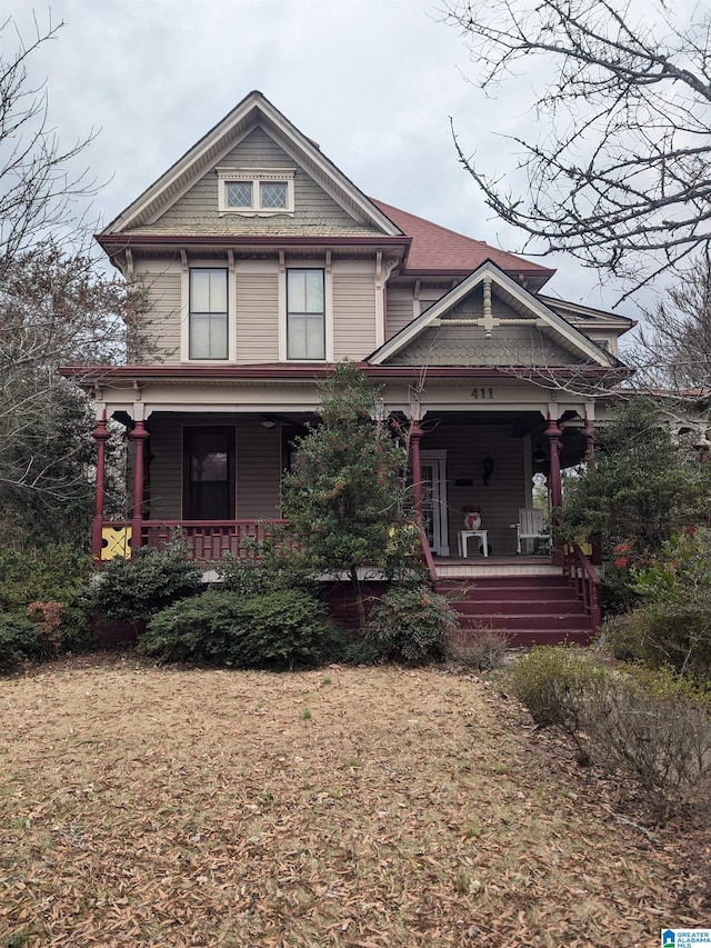 victorian home featuring covered porch and a front lawn