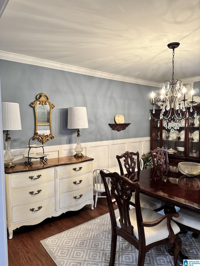 dining area with crown molding, a chandelier, and dark hardwood / wood-style flooring