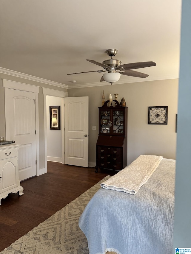 bedroom featuring crown molding, dark wood-type flooring, and ceiling fan