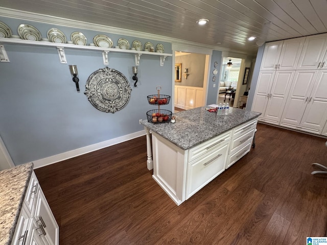 kitchen with white cabinets, light stone counters, and dark wood-style floors