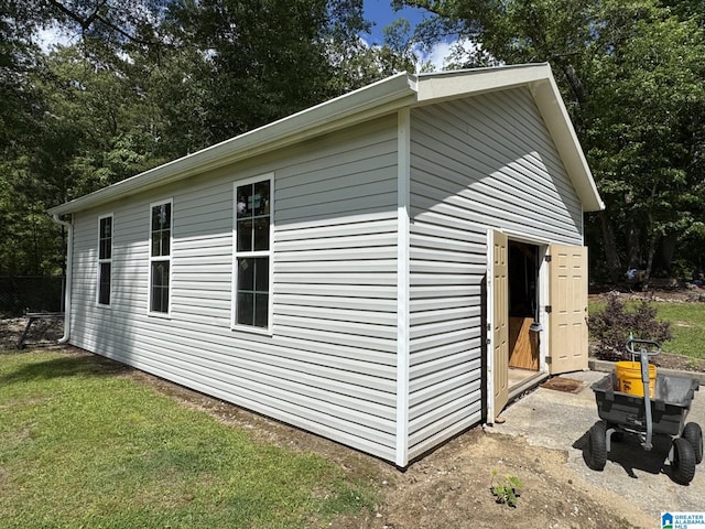 view of side of property featuring an outbuilding and a lawn