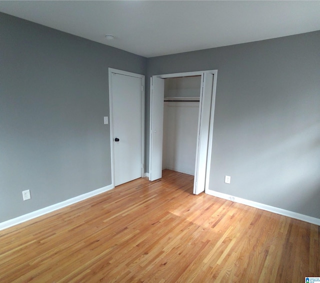 unfurnished bedroom featuring light hardwood / wood-style floors and a closet