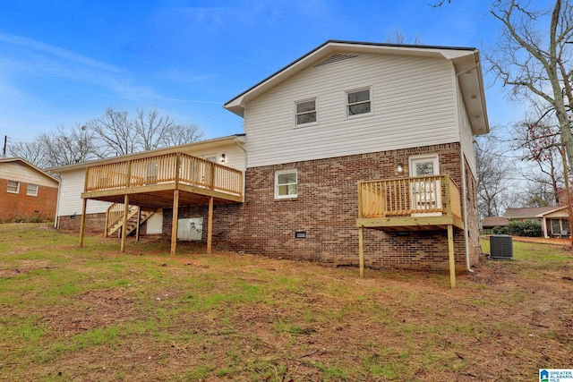 rear view of house featuring a wooden deck, a yard, and central AC