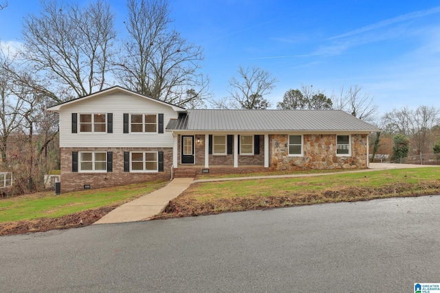 tri-level home featuring a porch and a front yard