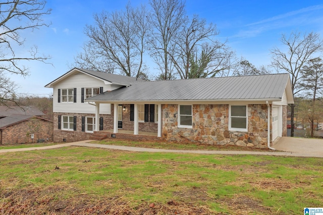 split level home featuring a porch, a garage, and a front lawn