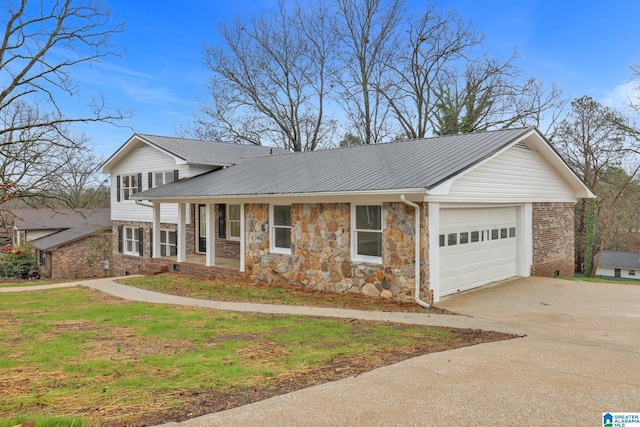 tri-level home featuring a garage, a front yard, and covered porch