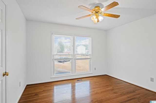 spare room featuring wood-type flooring, a textured ceiling, and ceiling fan