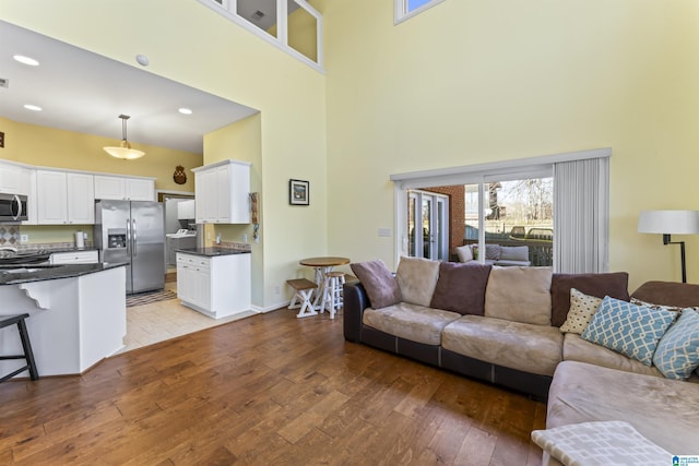 living room with a high ceiling and light hardwood / wood-style floors