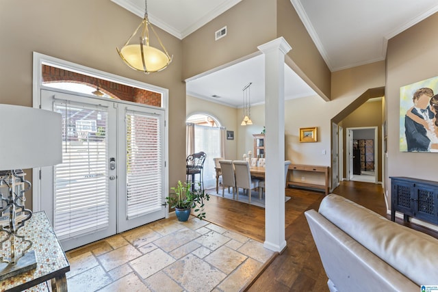 entrance foyer featuring crown molding, wood-type flooring, decorative columns, and french doors