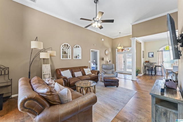 living room with crown molding, ornate columns, ceiling fan, and hardwood / wood-style flooring