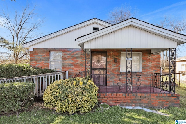 view of front of house with a porch and brick siding