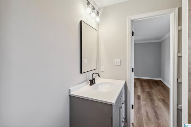 bathroom with vanity, wood-type flooring, and crown molding