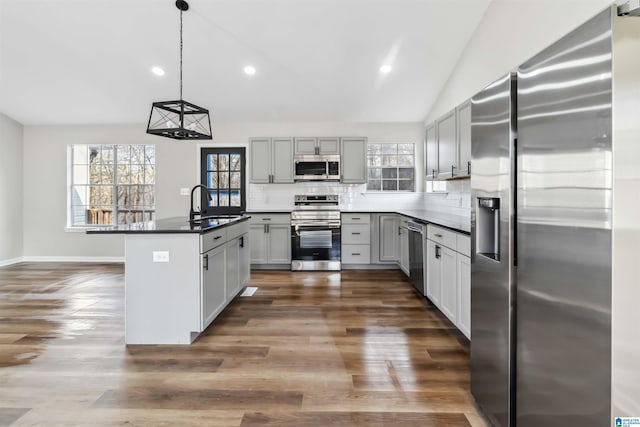 kitchen with sink, gray cabinetry, stainless steel appliances, decorative backsplash, and decorative light fixtures