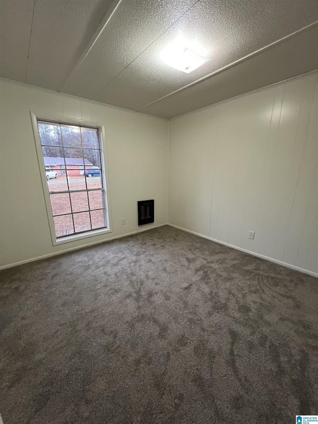 carpeted empty room with a textured ceiling