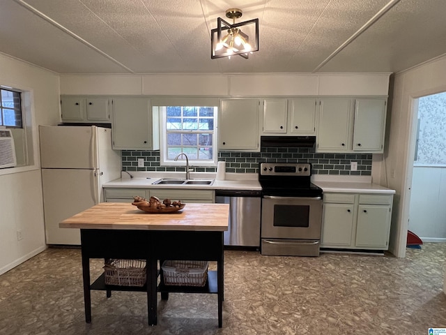 kitchen with wood counters, sink, backsplash, and stainless steel appliances