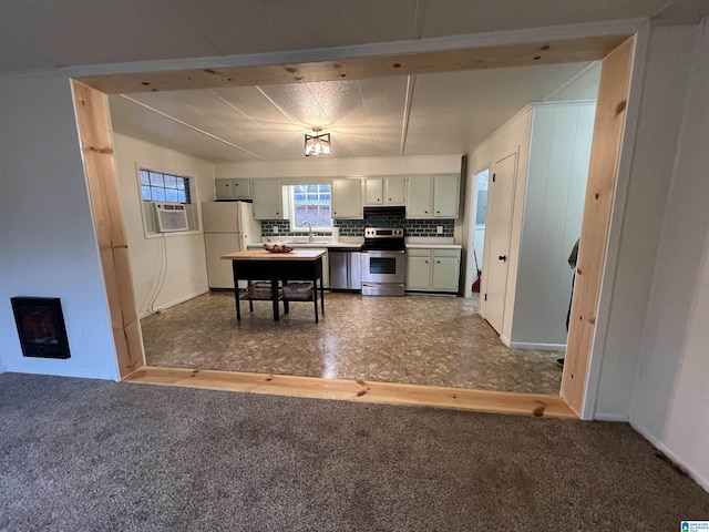 kitchen with sink, carpet, stainless steel appliances, a fireplace, and decorative backsplash