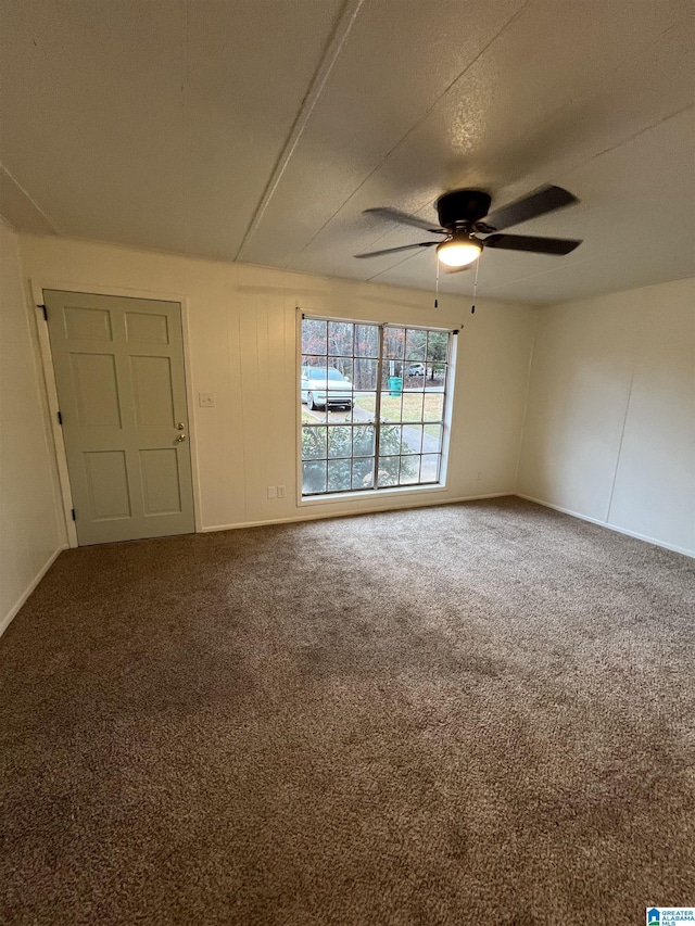 carpeted spare room featuring ceiling fan